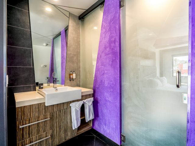 A modern bathroom with a sink, mirror, and shower