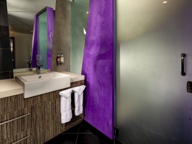 A modern bathroom with a sink, mirror, and shower