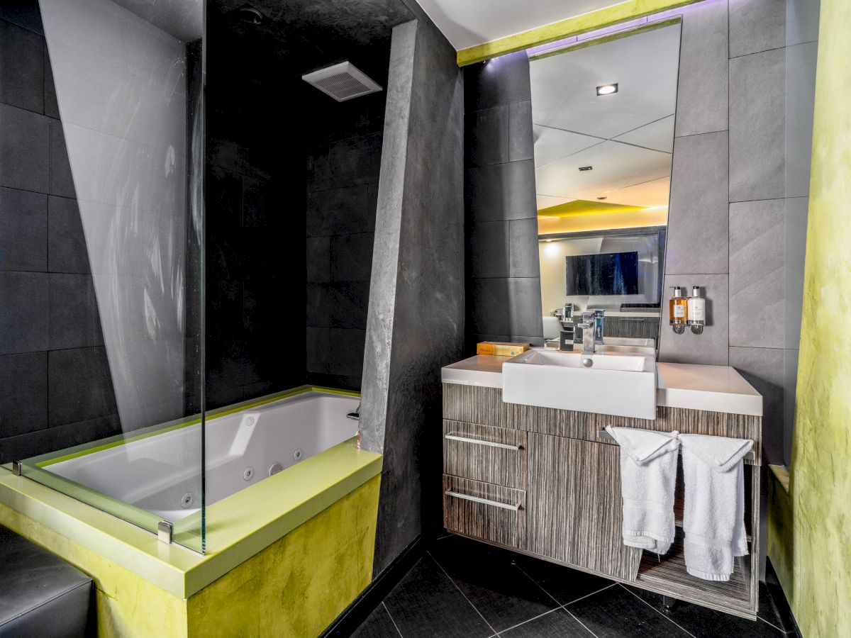 A modern bathroom with a bathtub, sink, and mirror