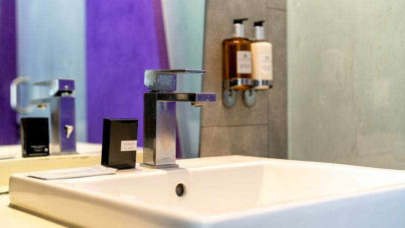 A clean bathroom sink with a silver faucet and toiletries