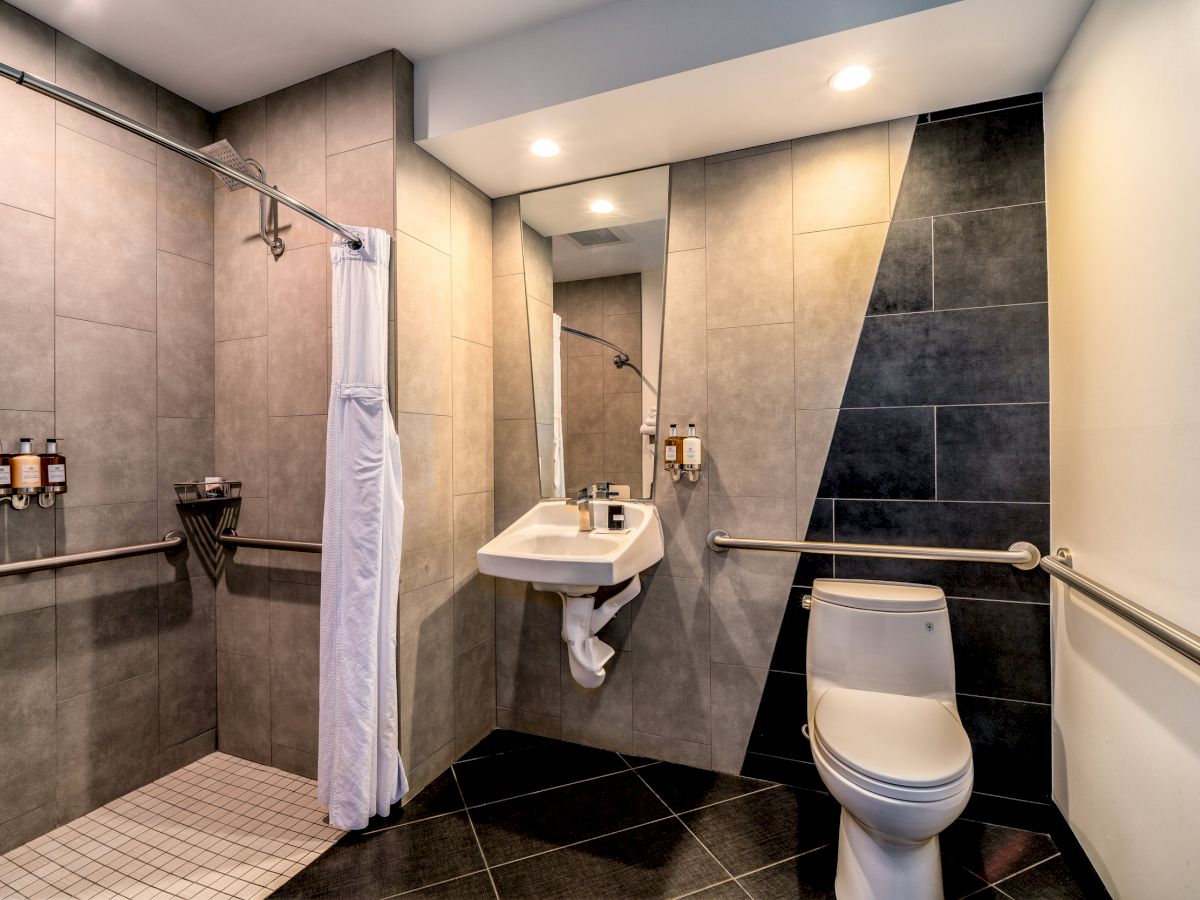 A clean and modern bathroom with a shower, sink, and toilet.