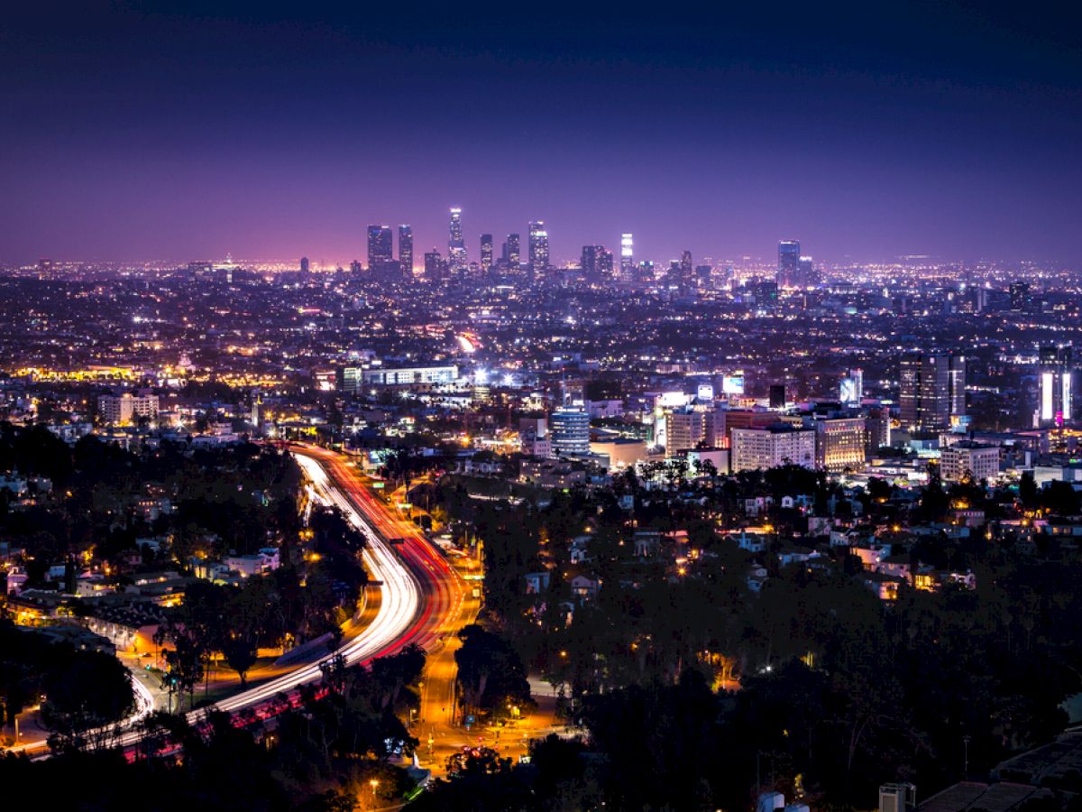 A nighttime cityscape with a highway and buildings